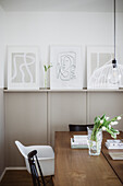 Dining area with modern artwork and bouquet of tulips on wooden table