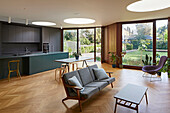 Küche, Essbereich und Sitzbereich in offenem Wohnraum mit Parkettboden und runden Oberlichtern
