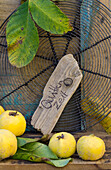 Cake rack with quinces, walnut leaves and wooden sign with writing