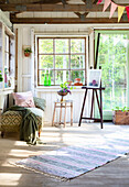 Sunlit glass veranda with easel and day bed