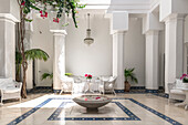 Patio with white rattan furniture, columns and tiles