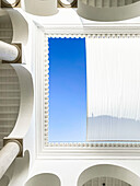 Light-flooded patio with white columns and blue sky