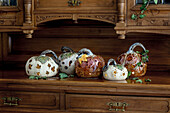 Halloween or Thanksgiving decorations with hand crafted ceramic pumpkins on rustic wooden cabinet