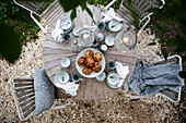 A view from above of a table set for coffee with lanterns in a garden