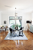 Dining room with oval table, modern chairs and parquet flooring