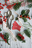 Silver spoon with name tag, holly bouquet and Christmas ribbon
