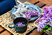 A spring place setting with lilac flowers on a table outdoors