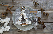Napkin decoration with fir tree made of cotton, cinnamon and larch twigs with name carts