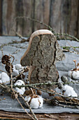 Mushroom cut out of bark, with cotton, larch twigs, and cones