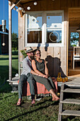 Caravan with wooden panelling, couple sitting on the terrace