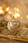 Christmas tree ball with glittering wreath and inscription Frohes Fest (Merry Christmas)