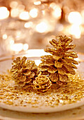 Mit goldenem Glitzer bestäubte Kiefernzapfen als Weihnachtsdeko