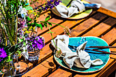 Gedeckter Tisch auf der mit Wildblumen geschmückten Sommerterrasse