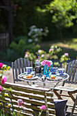 Vintage table with blue and white crockery and pastries on a patio