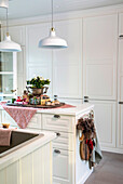 White country kitchen with pendant lights and gifts on the island