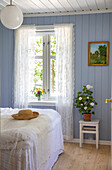 Nostalgisches Schlafzimmer mit hellblau gestrichener Holzverkleidung