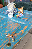 Kaffeetassen und Rehfigur auf blau gestrichener Tür als Tisch