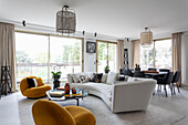Lounge mit Designer-Sitzmöbeln und raumhohen Fenstern