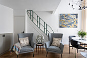 Light grey upholstered sofas with side table in front of stairs in a maisonette flat