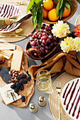 Set table with cheese, fruit and white wine