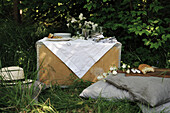 Picknick im Garten mit Holzkiste als Tisch und Sitzkissen