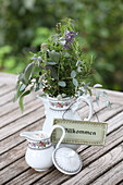 Herb bouquets and scented candle on the outdoor patio table