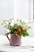 Rose hips and yarrow in vase