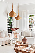 White seating furniture, Moroccan cushions and tables and wicker lamps in the living room
