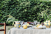 Gedeckter Tisch mit Zitronen dekoriert, im Garten