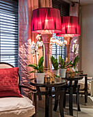Oversized illuminated lamp and orchid on a side table