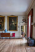Spacious reception room with large gold-framed paintings in an English country house