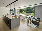 Kitchen island and dining area with modern chairs in front of open patio door