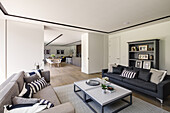 Elegant lounge with sofas, kitchen and dining area in the background