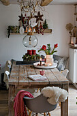 Christmas decoration with Advent wreath, bouquet of flowers and hanging stars in the dining room