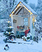 Weihnachtlich dekorierte Laube in schneebedecktem Garten