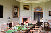 Gedeckter Tafel mit grünem Porzellangeschirr und antike Stühle im Esszimmer