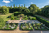 Box tree lined perennial beds in English country house garden