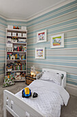 Toddler bed in the children's room with striped wallpaper