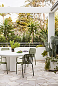 Concrete dining table with green chairs on patio