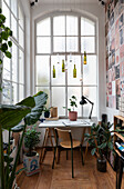 Schreibtisch im Wintergarten mit Altbaufenstern und Zimmerpflanzen