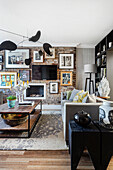 Wohnzimmer mit schwarzem Mobile und Kunstwerken an Ziegelwand