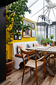 Dining area in the conservatory, artwork on yellow wall