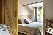 Blick durch offene Holzschiebetür auf Doppelbett