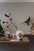 Kitchen counter decorated for Christmas with silver vase, with dried flowers on the wall