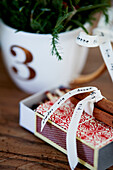 Cinnamon sticks tied together on top of matchbox and decorative cup with the number 3