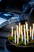 Weihnachtlich dekorierte Schale mit Moos und brennenden Kerzen