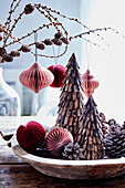 Christmas trees made of bark and honeycomb paper decorations in a wooden bowl