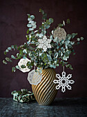 Eukalyptuszweige mit Schneeflockenanhängern in Retro Vase