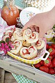 Pastries, strawberries, drink and preserving jar on a wooden tray