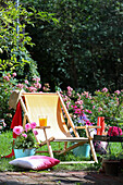 Deck chair with DIY cover in sunny garden, surrounded by flowers